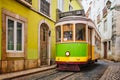 Famous vintage yellow tram 28 in the narrow streets of Alfama district in Lisbon, Portugal