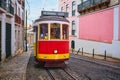 Famous vintage yellow tram 28 in the narrow streets of Alfama district in Lisbon, Portugal Royalty Free Stock Photo