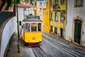 Famous vintage yellow tram 28 in the narrow streets of Alfama district in Lisbon, Portugal