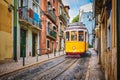 Famous vintage yellow tram 28 in the narrow streets of Alfama district in Lisbon, Portugal