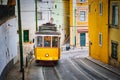 Famous vintage yellow tram 28 in the narrow streets of Alfama district in Lisbon, Portugal