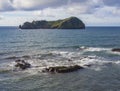 Famous volcanic islet of Vila Franca do Campo, small green crater island near sea shore with rocks ocean, blue sky and Royalty Free Stock Photo