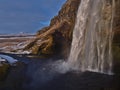 Famous waterfall Seljalandsfoss on the south coast of Iceland near ring road with colorful rainbow. Royalty Free Stock Photo