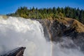 Famous waterfall Tannforsen northern Sweden, with a rainbow in the mist and rapid flowing cascades of water