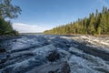 Famous waterfall Tannforsen northern Sweden, with a rainbow in the mist and rapid flowing cascades of water