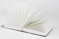 Fan open small unfold notepad with blank light beige pages. Notebook, sketchbook, book. White back Royalty Free Stock Photo