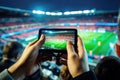 Fan records football action on smartphone. 5G concept