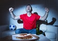 Fanatic football fan man watching soccer game on tv celebrating