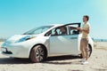 Stylish man wearing beige trousers standing near his new fancy car Royalty Free Stock Photo