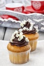 Fancy chocolate cupcakes on wooden table. Royalty Free Stock Photo