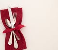 Fancy Christmas or Valentines Day Table Place Setting with cloth red napkin, silverware, and bow on creamy white tablecloth backgr Royalty Free Stock Photo