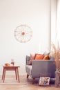 Fancy clock on white wall of elegant living room interior