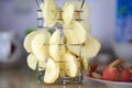Fancy creative steel fruit dryer. Sliced apple slices. Nearby is a plate with red apple peels.