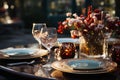 A fancy dinner table, wine glasses, a candle, white and red flowers in a see through vase on a black surface, a dark Royalty Free Stock Photo