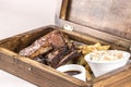 Fancy dish with grilled pork ribs, barbecue sauce, French fries, Coleslaw salad, in a wooden box Royalty Free Stock Photo