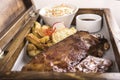 Fancy dish with grilled pork ribs, barbecue sauce, French fries, Coleslaw salad, in a wooden box