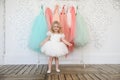 Kid girl in dress near hanger with festive clothes