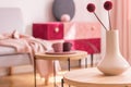 Fancy flower in beige vase on wooden coffee table in fashionable living room