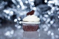 Fancy food cupcake with delicious white vanilla icing and chocolate heart and blue sparkle background Royalty Free Stock Photo