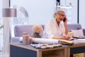 Fancy-looking aged CEO arranging meeting via phone in sophisticated office