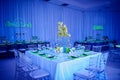 Fancy orchid flower arrangement set up for a wedding party in a ballroom with lucite chairs and decoration Royalty Free Stock Photo