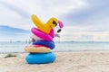 Fancy swim rings on sand beach with blue sea and blue sky background in summer holiday day Royalty Free Stock Photo