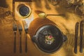 Fancy silverware, crockery, plates and other stuff on a table, with some sort of a fancy food, looking from above