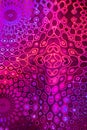Fancy surrealistic orange-violet pattern like kaleidoscope on holographic paper.