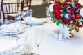 Fancy table set for dinner with flower composition in restaurant, luxury interior background. Wedding elegant banquet decoration Royalty Free Stock Photo