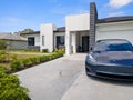 Fancy Tesla Model 3 parked in front of a modern house in Cape Coral, United States