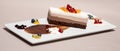 Fancy triple mousse chocolate dessert, decorated with forest fruits and chocolate sauce