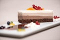 Fancy triple mousse chocolate dessert, decorated with forest fruits and chocolate sauce