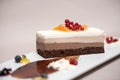 Fancy triple mousse chocolate dessert, decorated with forest fruits and chocolate sauce