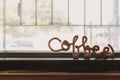 Fancy wire shaped into word COFFEE stand on the edge of window.