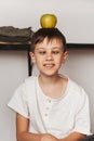 Fanny boy in the kitchen with a green apple. Healthy food for children concept Royalty Free Stock Photo