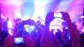 Fans hands recording video and taking pictures with smart phones at music concert. People crowd partying at rock concert