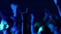 Fans Raise Hands in Front of Bright Colorful Strobing Lights on Stage at a concert in a night club.