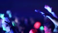 Fans Raise Hands and takes a photos in Front of Bright Colorful Strobing Lights on Stage.