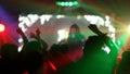 Fans Raise Hands and takes a photos in Front of Bright Colorful Strobing Lights on Stage.