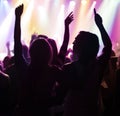 Fans in silhouette at music festival, hands in air and neon lights with energy at live concert event. Dance, fun and Royalty Free Stock Photo