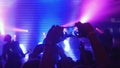 Fans waving their hands recording video and taking pictures with smart phones at music concert. People crowd partying at