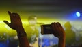 Fans waving their hands recording video and taking pictures with smart phones at rock concert. Royalty Free Stock Photo