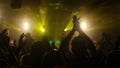 Fans waving their hands at rock concert in night club on beautiful golden lights Royalty Free Stock Photo