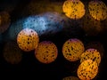 Fantastic abstract background image looking through a rainy window with colorful round blurred bokeh spots of street lights and Royalty Free Stock Photo