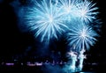 Fantastic aqua blue color fireworks exploding in to the night sky over the bay Royalty Free Stock Photo