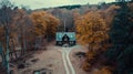 Fantastic autumn landscape with glowing wooden cabin in autumn forest. Cozy house in Carpathian mountains. Royalty Free Stock Photo