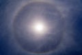 Fantastic beautiful sun halo phenomenon in the blue sky. Rainbow in the form of a circle around the sun. Royalty Free Stock Photo