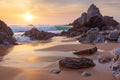 Fantastic big rocks and ocean waves at golden sundown Royalty Free Stock Photo