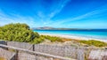 Fantastic blooming flowers on Famous La Pelosa beach with fence next to Royalty Free Stock Photo