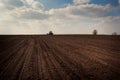 Fantastic blue sky above ploughed field tractor on skyline Royalty Free Stock Photo